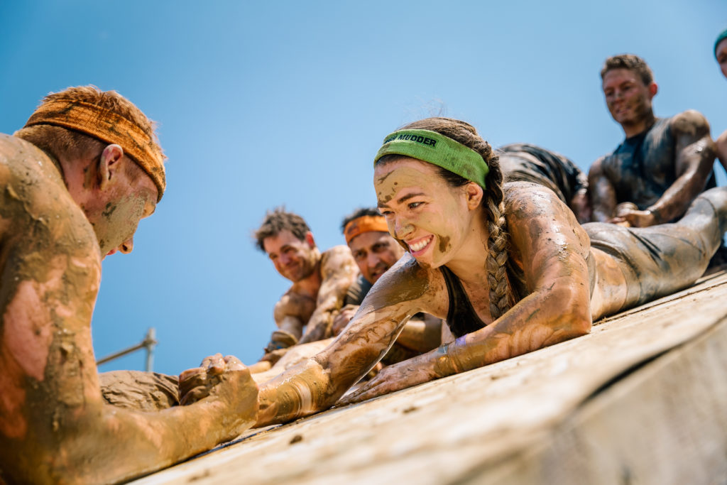 Participants smiling while helping each other climb the Everest