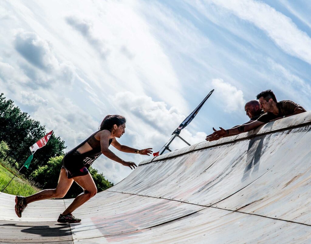 Participant running up the Tough Mudder obstacle Everest 2.0