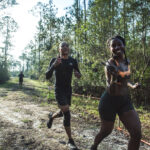 tough mudder people running in wood