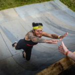 Participant jumping up Everest obstacle.